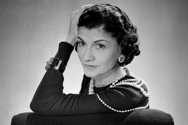 Coco Chanel, in posa mentre indossa delle sue creazioni. È considerata il simbolo di una eleganza moderna. Innovò e rivoluziono il modo di vestire di intere generazioni.